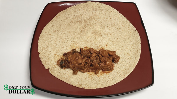 Adding beef and bean filling to burrito