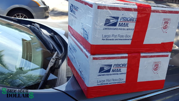 Two military care packages in large flat rate usps boxes on car