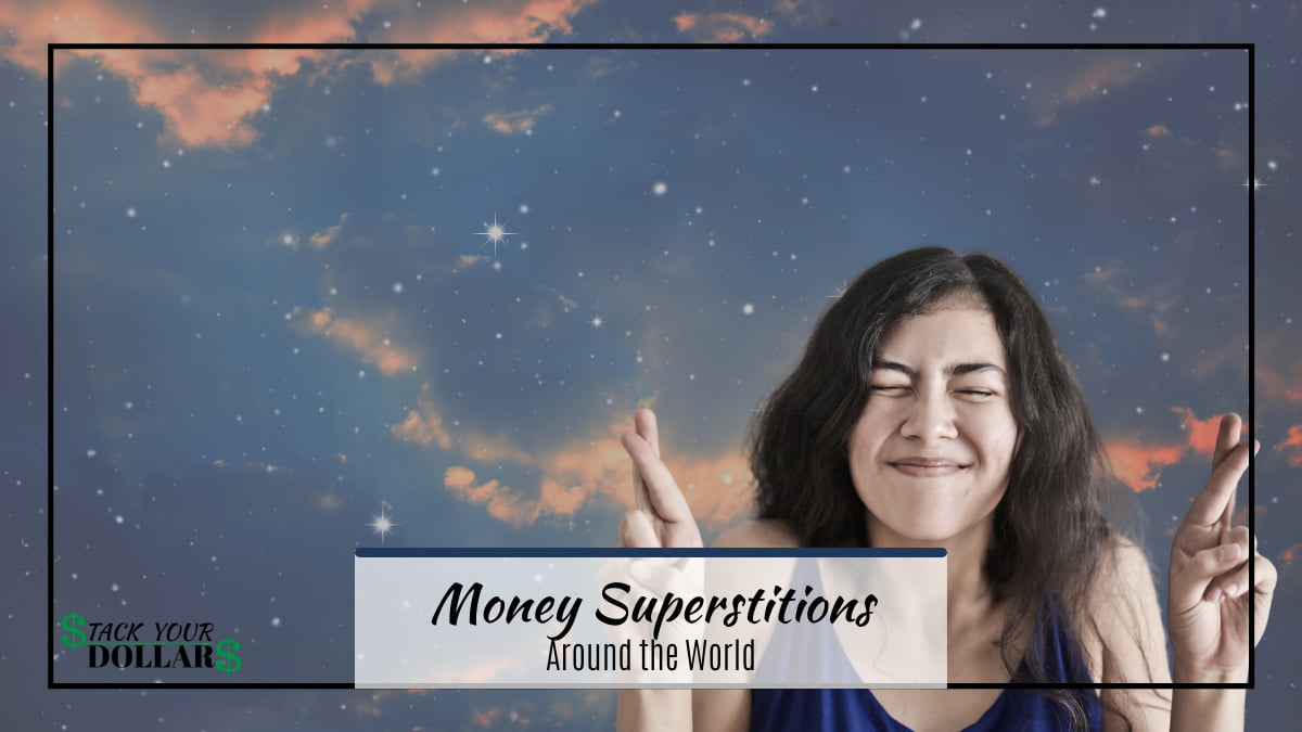 Woman crossing fingers with starry background with text of money superstitions around the world