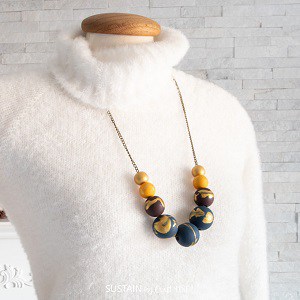 Wood bead necklaces over white sweater